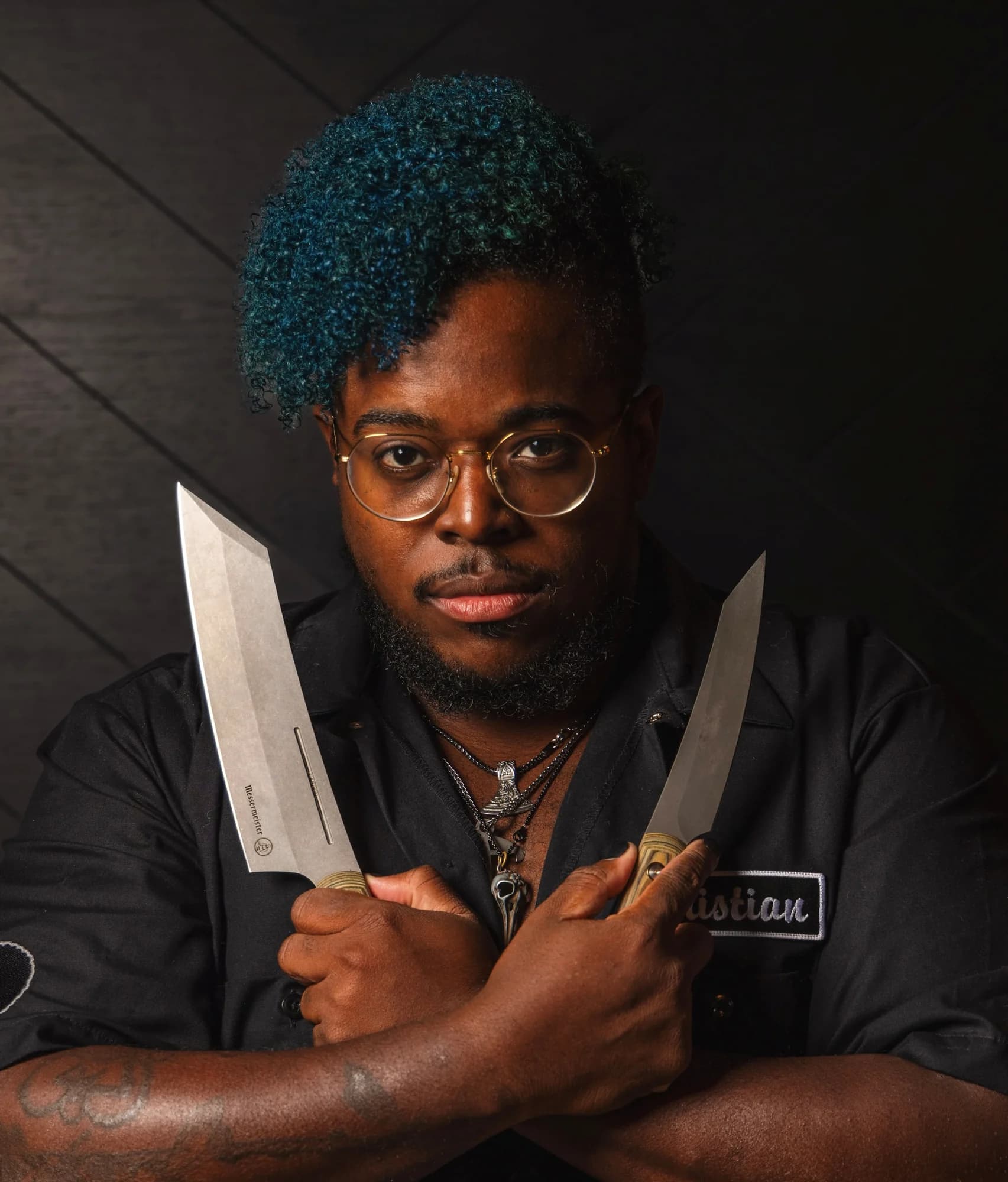 Chef Christian Gill holding two chef's knives