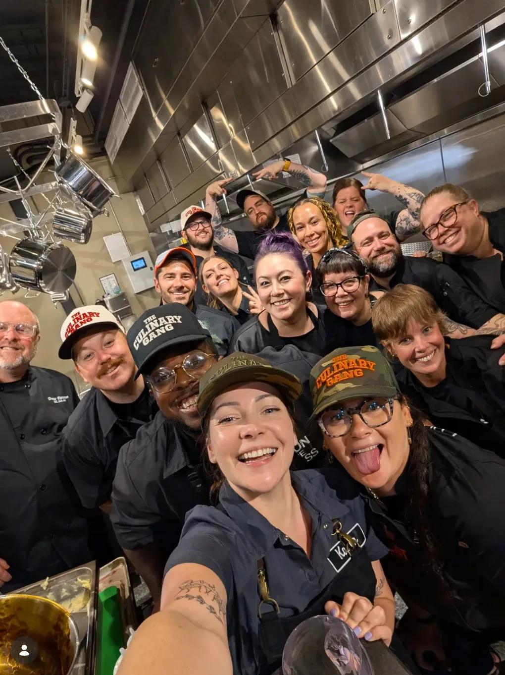 The Culinary Gang crew crowded into a kitchen, in Culinary Gang hats